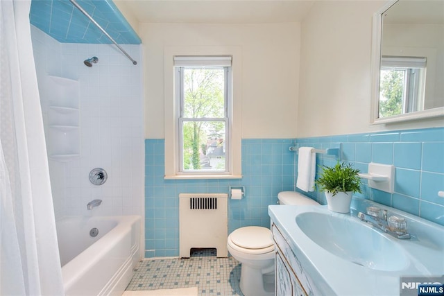 full bathroom with radiator, tile patterned floors, a wealth of natural light, and tile walls