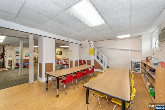 recreation room featuring wood finished floors and a drop ceiling