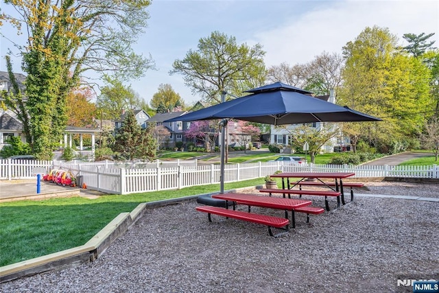 view of community with a yard and fence