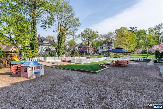 exterior space featuring a residential view, playground community, and fence