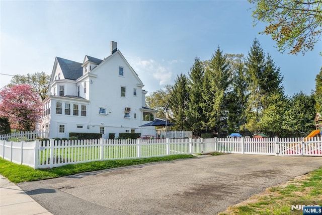view of home's exterior featuring a yard, a fenced front yard, stucco siding, and a chimney