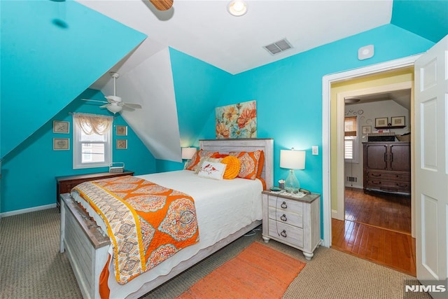 carpeted bedroom with a ceiling fan, baseboards, visible vents, and vaulted ceiling