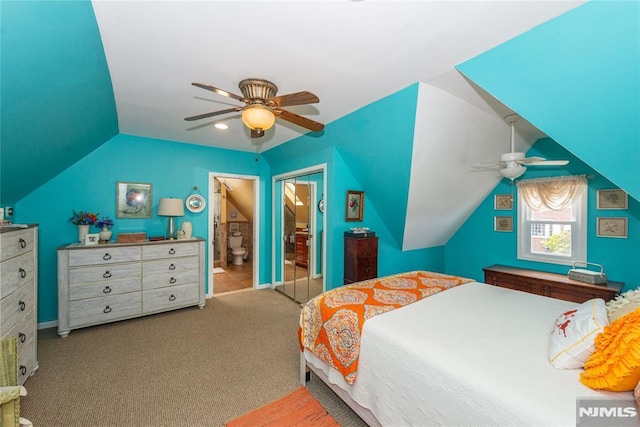 bedroom featuring a ceiling fan, carpet, ensuite bath, and vaulted ceiling
