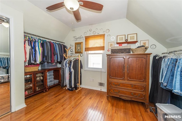 spacious closet featuring light wood-style floors, visible vents, a ceiling fan, and lofted ceiling
