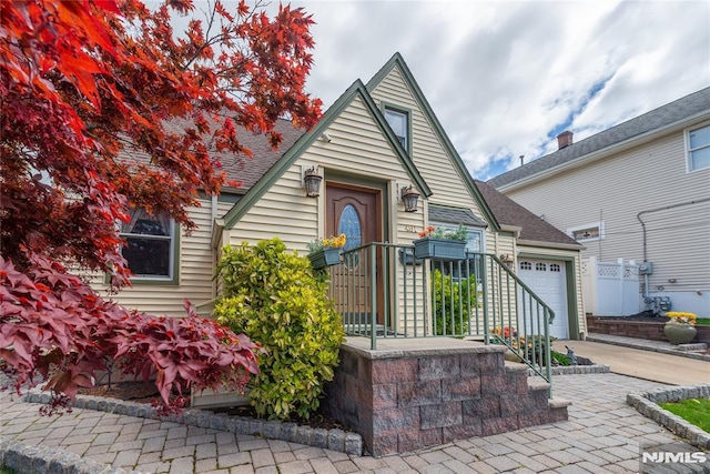 bungalow-style house featuring an attached garage, driveway, and a shingled roof