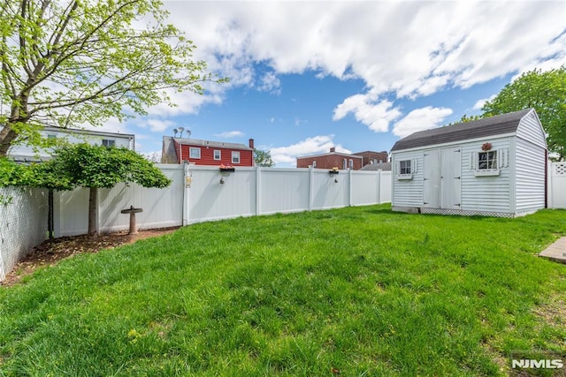 view of yard with a fenced backyard, an outdoor structure, and a shed