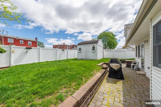 view of yard featuring an outbuilding, a fenced backyard, a patio area, and a storage unit