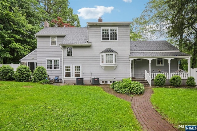 785 Ridgewood Rd, Twp Of Washington, NJ 07676 - back of property featuring a chimney, a lawn, covered porch, and a shingled roof