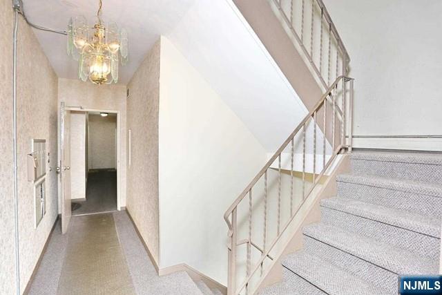 57 Brookway Ave Unit 2C, Englewood, NJ 07631 - stairway with carpet flooring, a notable chandelier, and a baseboard radiator