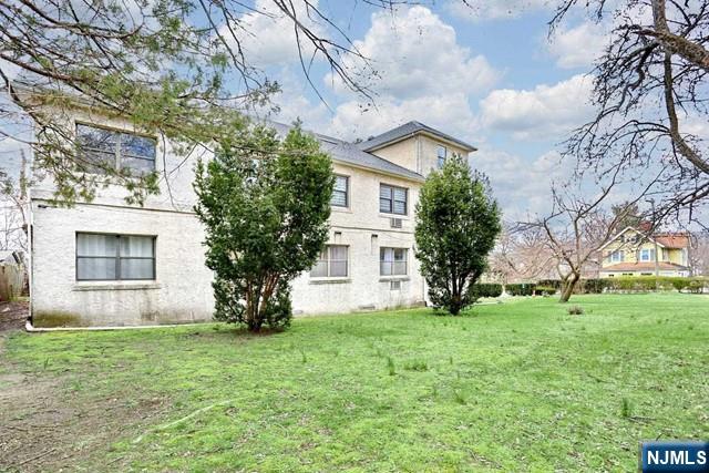 57 Brookway Ave Unit 2C, Englewood, NJ 07631 - rear view of house with stucco siding and a yard