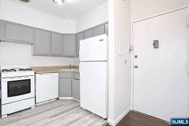 57 Brookway Ave Unit 2C, Englewood, NJ 07631 - kitchen featuring white appliances, light wood-style floors, light countertops, a sink, and gray cabinetry