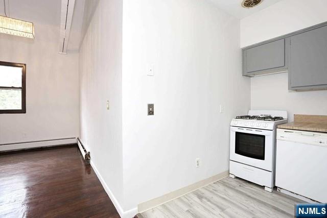 57 Brookway Ave Unit 2C, Englewood, NJ 07631 - kitchen featuring white appliances, baseboards, light countertops, light wood finished floors, and gray cabinetry