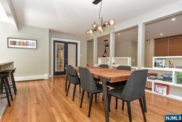 dining area with recessed lighting, a baseboard radiator, light wood finished floors, and a chandelier