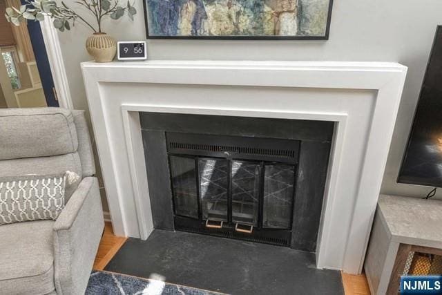 interior details featuring a fireplace with flush hearth and concrete floors