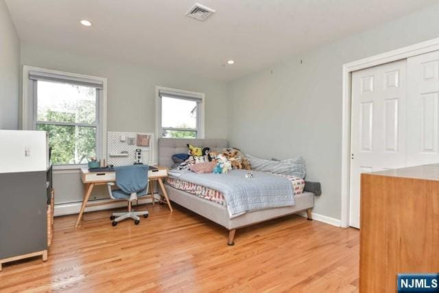 bedroom featuring multiple windows, light wood finished floors, and visible vents