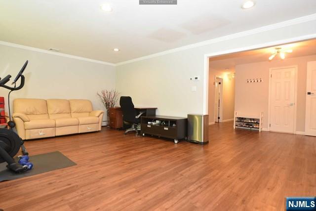 workout room with recessed lighting, ornamental molding, and wood finished floors