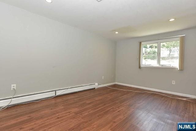 empty room with baseboards, a baseboard radiator, wood finished floors, and recessed lighting