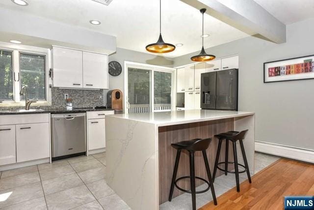 kitchen with white cabinets, a sink, dishwasher, decorative backsplash, and black fridge with ice dispenser