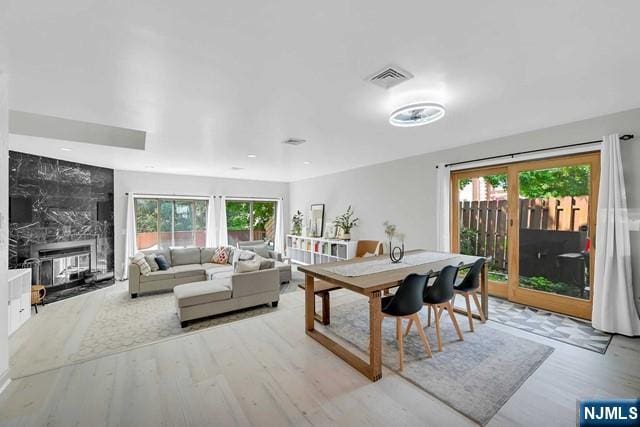 dining area featuring a wealth of natural light, visible vents, and wood finished floors