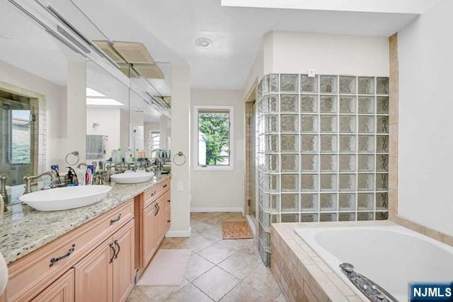 full bath with a stall shower, a bath, a sink, tile patterned floors, and double vanity
