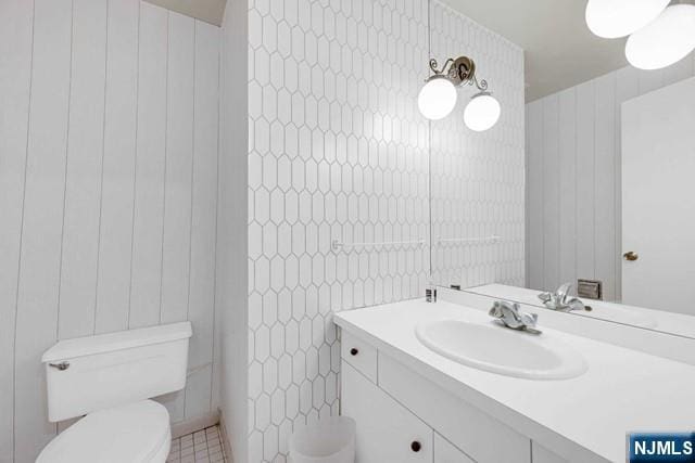 bathroom featuring tile walls, toilet, and vanity
