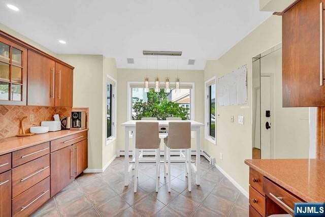 kitchen featuring decorative backsplash, brown cabinetry, baseboards, and recessed lighting