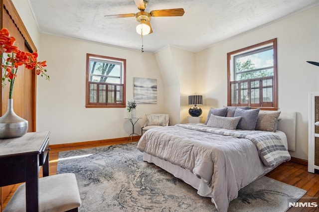bedroom with baseboards, ornamental molding, a ceiling fan, and wood finished floors