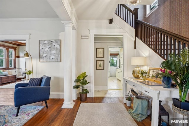 foyer with stairs, baseboards, decorative columns, ornamental molding, and hardwood / wood-style flooring