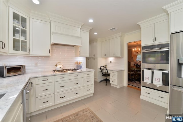 kitchen with appliances with stainless steel finishes, backsplash, a chandelier, white cabinets, and recessed lighting