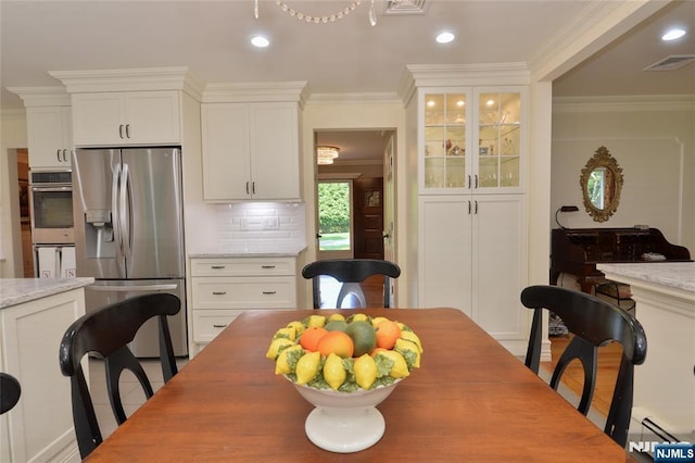 dining room featuring crown molding, a baseboard heating unit, and recessed lighting