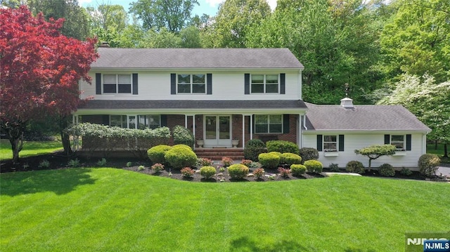 colonial-style house with a front lawn and a chimney