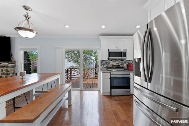 kitchen with backsplash, white cabinets, appliances with stainless steel finishes, and dark wood-type flooring