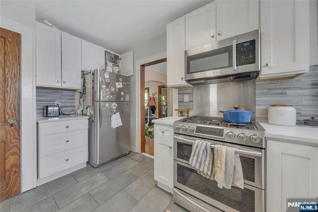 kitchen featuring stainless steel appliances, white cabinets, and decorative backsplash