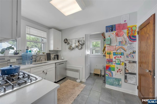 kitchen featuring a sink, stainless steel appliances, healthy amount of natural light, and light countertops
