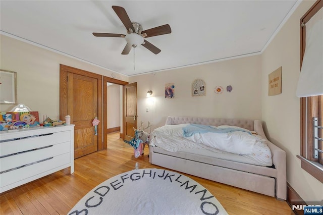 bedroom with light wood-style flooring, ceiling fan, and ornamental molding