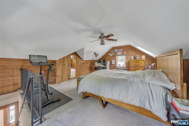 bedroom with wood walls, lofted ceiling, carpet flooring, and a ceiling fan
