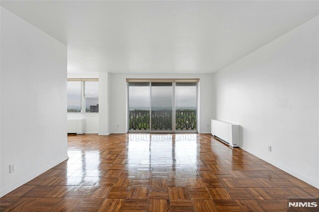 empty room featuring radiator and baseboards