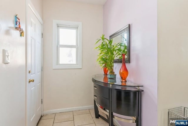 doorway to outside featuring baseboards and light tile patterned floors