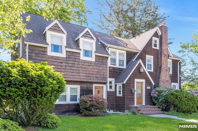400 Prospect Ave, Oradell, NJ 07649 - view of front of house featuring roof with shingles, a front yard, and a chimney