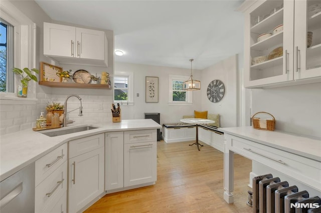 400 Prospect Ave, Oradell, NJ 07649 - kitchen featuring a sink, white cabinets, radiator, light countertops, and backsplash