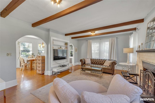 400 Prospect Ave, Oradell, NJ 07649 - living room featuring arched walkways, beam ceiling, healthy amount of natural light, wood finished floors, and baseboards