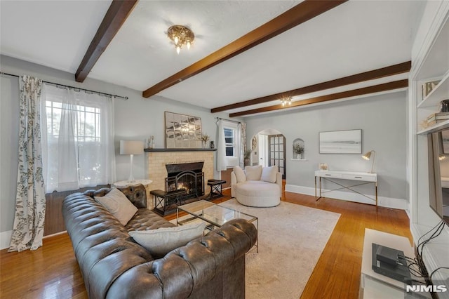 400 Prospect Ave, Oradell, NJ 07649 - living area with arched walkways, wood finished floors, baseboards, beamed ceiling, and a brick fireplace