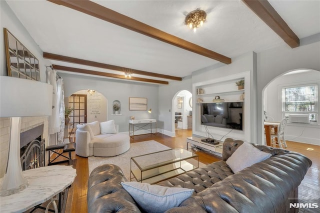 400 Prospect Ave, Oradell, NJ 07649 - living area featuring arched walkways, wood finished floors, beamed ceiling, baseboards, and a lit fireplace
