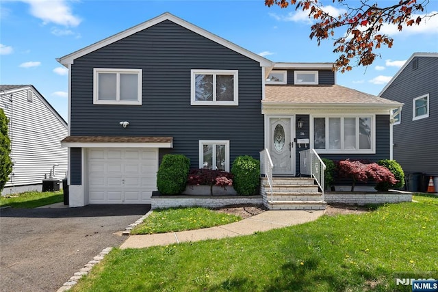 tri-level home with central AC unit, driveway, roof with shingles, and an attached garage