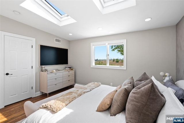 bedroom featuring a skylight, dark wood-type flooring, visible vents, and recessed lighting