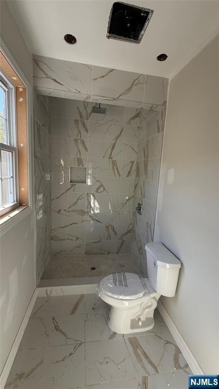 full bath featuring toilet, baseboards, a marble finish shower, and marble finish floor