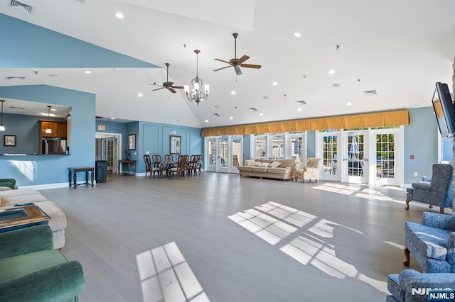 living room with wood finished floors, french doors, ceiling fan with notable chandelier, high vaulted ceiling, and visible vents