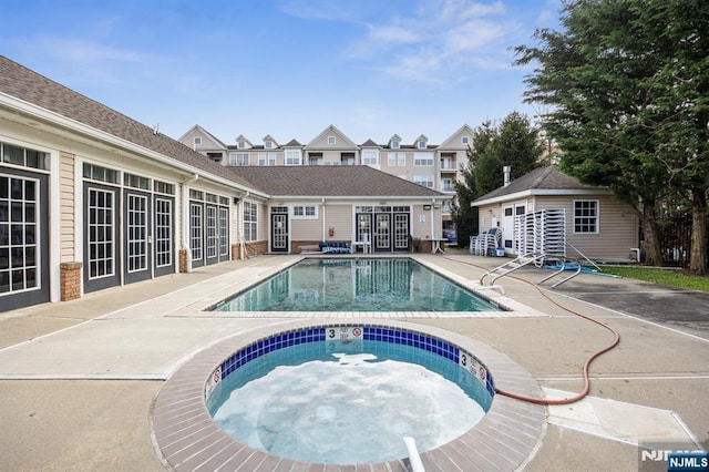 community pool with a hot tub, a residential view, french doors, and a patio