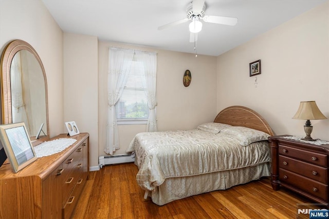 bedroom with a baseboard radiator, wood finished floors, and a ceiling fan