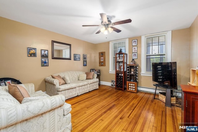 living room with a ceiling fan, hardwood / wood-style flooring, baseboards, and baseboard heating